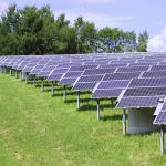 modern solar panels in a beautiful green field